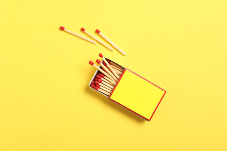 Matches and box on yellow background, flat lay. Mockup for designの写真素材
