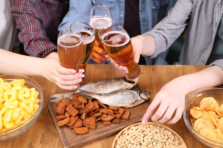 Friends with beer and snacks at wooden table, closeupの写真素材