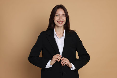 Happy woman in suit on beige backgroundの写真素材