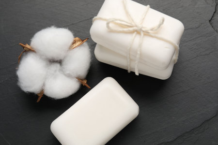Soap bars and cotton flower on black table, above viewの写真素材