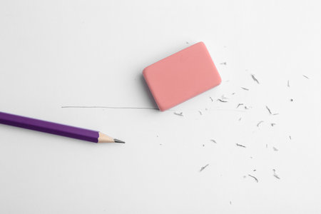 Graphite pencil and eraser on paper sheet, top viewの写真素材