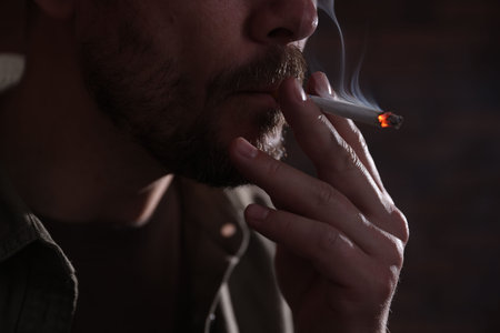 Man smoking cigarette on blurred background, closeupの写真素材