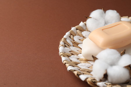Soap bars and cotton flowers on brown background, closeup. Space for textの写真素材