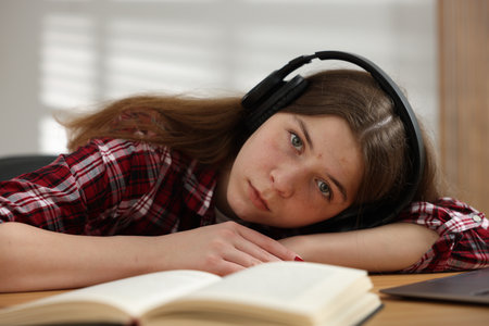 Stressed teenage girl studying at desk indoorsの写真素材