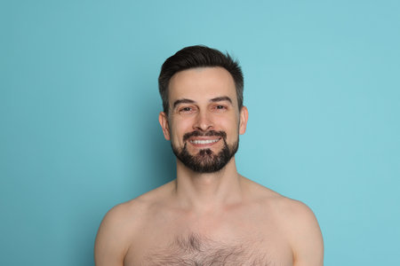 Smiling man before shaving on light blue backgroundの写真素材