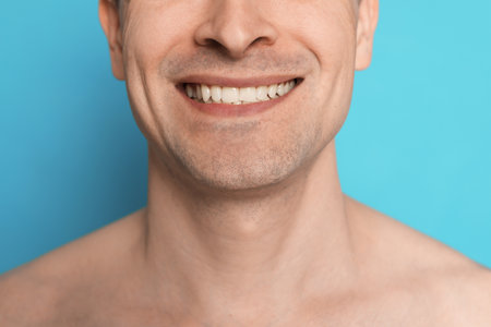Smiling man after shaving on light blue background, closeupの写真素材