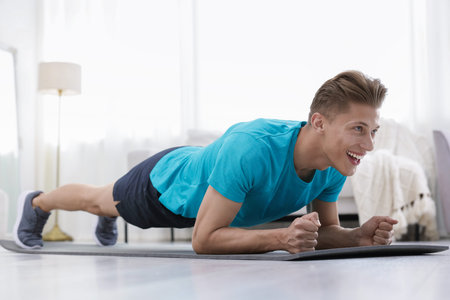 Man doing plank exercise at home. Sport and healthy lifestyleの写真素材