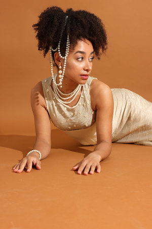Fashionable portrait of beautiful Brazilian woman in stylish outfit on light brown background