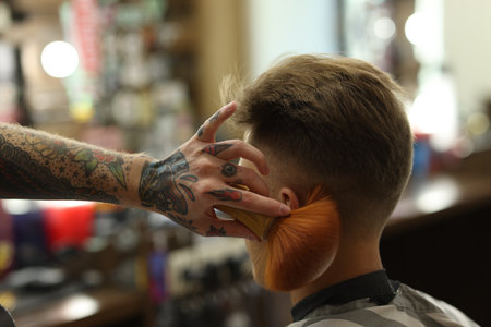Professional barber working with client in barbershop, closeupの写真素材