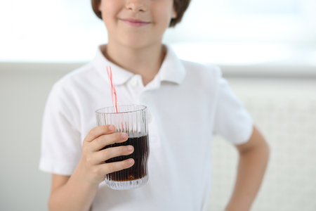 Little boy with glass of refreshing soda at home, selective focusの写真素材