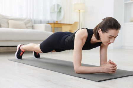 Woman doing plank exercise at home. Sport and healthy lifestyle