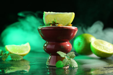 Hookah bowl with limes, mint and smoke on black table, closeupの写真素材