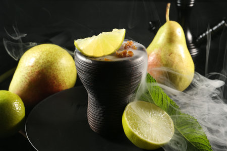 Hookah bowl with fruits, mint and smoke on black table, closeupの写真素材