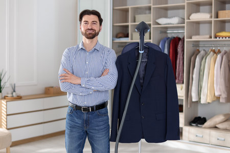 Man with stand steamer and jacket indoorsの写真素材