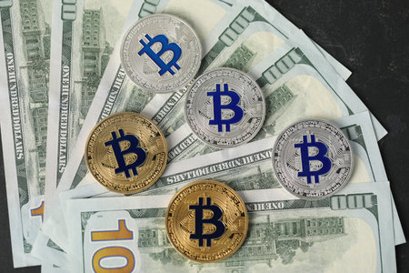 Cryptocurrency. Bitcoins and dollar banknotes on black table, flat lay