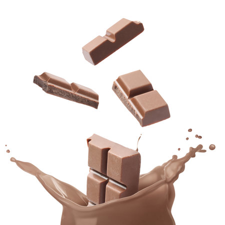 Chocolate pieces falling into splashing chocolate milk against white backgroundの写真素材