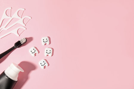 Different oral care products and teeth figures on pink background, flat lay. Space for textの写真素材