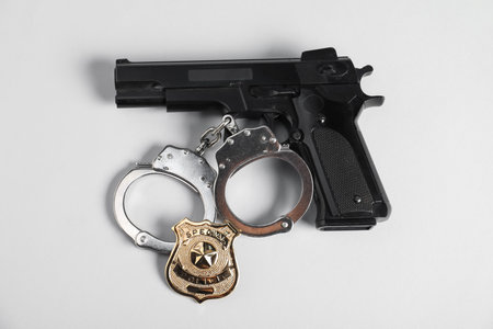 Police badge, gun and handcuffs on white background, above viewの写真素材