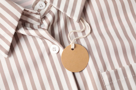 Cardboard tag on striped shirt, top viewの写真素材