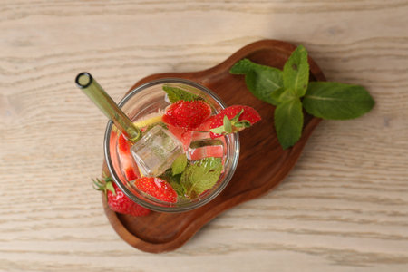 Tasty refreshing drink with strawberries, lemon and mint on wooden table, top viewの写真素材