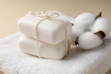 Soap bars, towel and cotton flower on dark beige background, closeupの写真素材