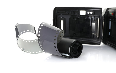 Roll of photographic film and photo camera isolated on whiteの写真素材