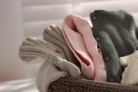 Wool baby clothes in basket on light background, closeupの写真素材