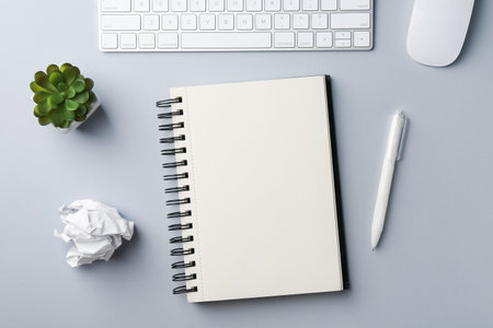 Notebook, pen, crumpled paper, floral decor, computer keyboard and mouse on gray background, flat layの写真素材