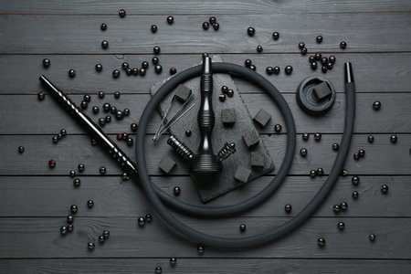 Hookah, coal and currants on black wooden table, flat lay