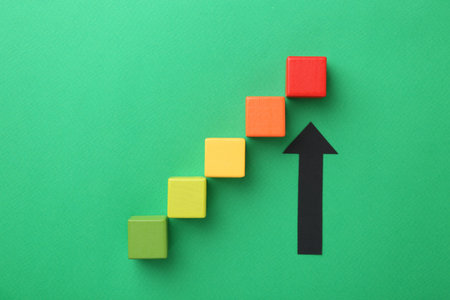 Maximum. Arrow pointing at colorful cubes on green background, flat layの写真素材