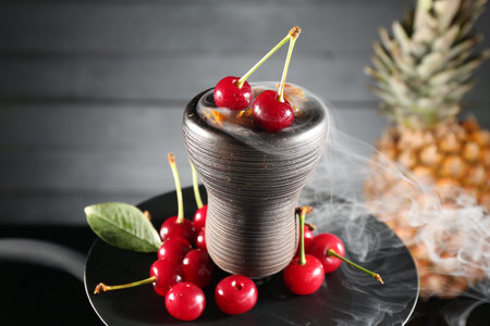 Hookah with cherries and smoke on black background, closeup