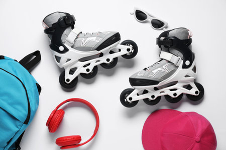 Flat lay composition with roller skates on white background