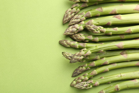 Fresh ripe raw asparagus on green background, closeup. Space for textの写真素材