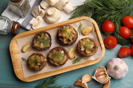 Delicious stuffed mushrooms and products on light blue wooden table, flat layの写真素材