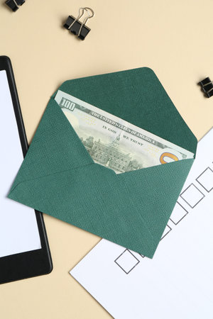 Money bonus. Envelope with dollar banknote, clipboard, checklist and binder clips on beige...