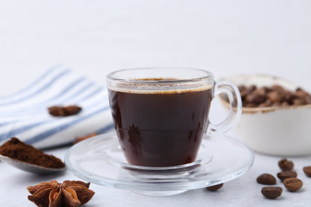Cup of aromatic coffee, beans and star anise on white table, closeupの写真素材