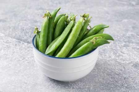 Fresh ripe green peas on gray table, closeup