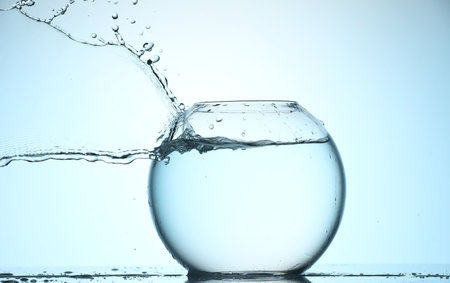 Glass aquarium with water on light blue backgroundの写真素材