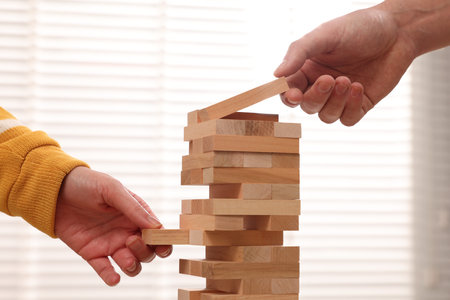 Lviv, Ukraine - December 08, 2023: People playing Jenga tower at home, closeup