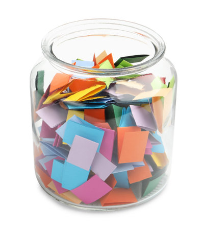 Colorful paper pieces in glass jar isolated on whiteの写真素材