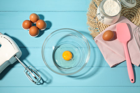 Making whipped cream. Bowl, hand mixer and ingredients on light blue wooden table, flat layの写真素材