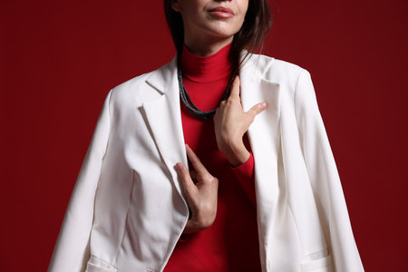 Beautiful woman in stylish outfit on red background, closeupの写真素材