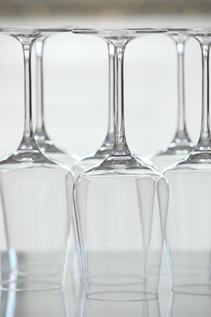 Upturned empty clean glasses on mirror surface against blurred background, closeupの写真素材