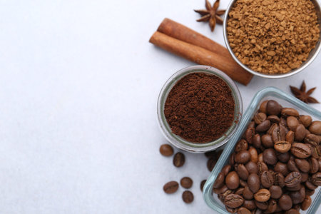 Different types of instant coffee, beans and spices on light table, flat lay. Space for text