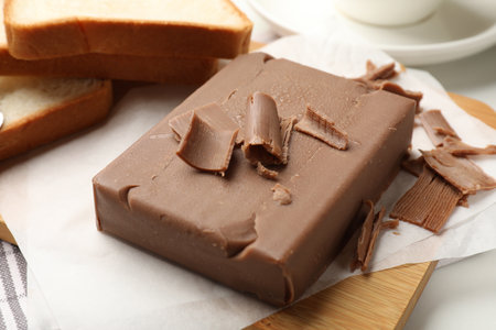 Block of tasty chocolate butter and bread slices on table, closeupの写真素材