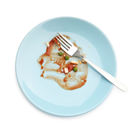 Dirty plate with tomato sauce, peas, bread crumbs and fork isolated on white, top viewの写真素材