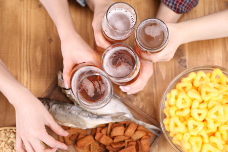 Friends with beer and snacks at wooden table, top viewの写真素材