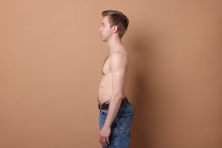 Man before weight loss on beige backgroundの写真素材