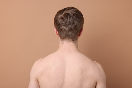 Man after scoliosis treatment on beige background, back viewの写真素材