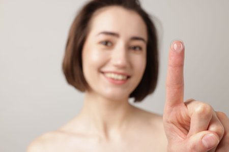 Woman with contact lens on light background, selective focusの写真素材